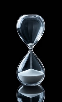 Elegant glass hourglass captures time. A clear glass hourglass stands on a smooth surface, filled with fine white sand, measuring time in an artistic way. photo