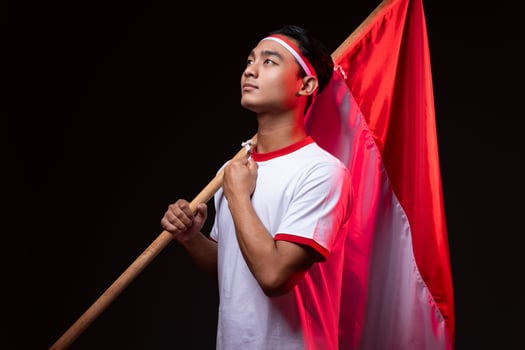Portrait of Young Asian Man with Red White Indonesian Flag Celebrating Independence Day Isolated photo
