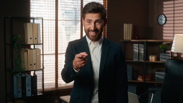 Happy smiling man male recruiter mature businessman index finger hey you gesture pointing at wrist like wristwatch showing time late invite join business team office inviting come here welcome hiring photo