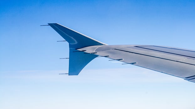 Airplane wing with a view of the blue sky from the window. photo