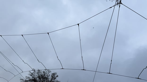 Wind weary netting embraces the moody sky, whispering of forgotten kite festivals and elusive dreams caught mid air photo