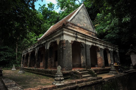 The old Buddhism church located in the forest surrounded by the trees photo