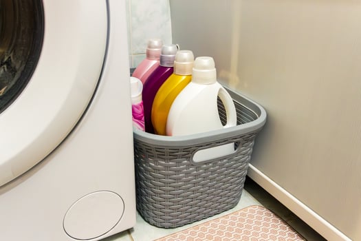 A basket with laundry detergent and other cleaning products photo