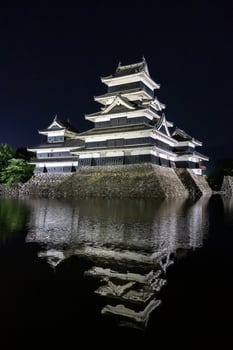 Night view of Matsumoto Castle reflecting in the water, Japan photo