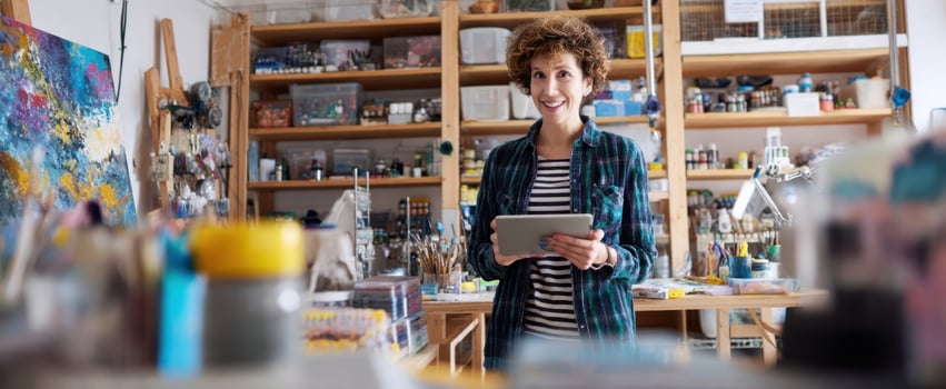 The artist smiling joyfully in her vibrant and creative studio space. photo