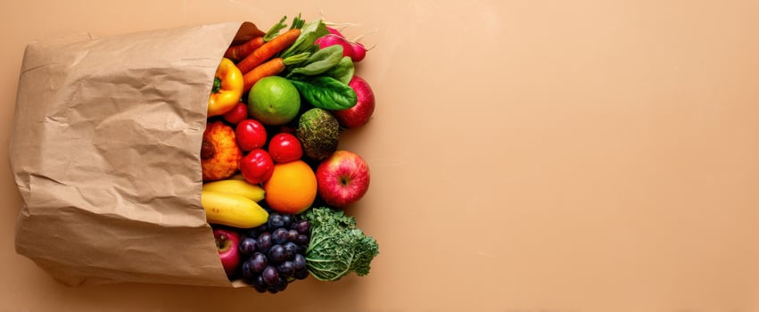 The vibrant assortment of fresh fruits and vegetables spilling from a paper bag photo
