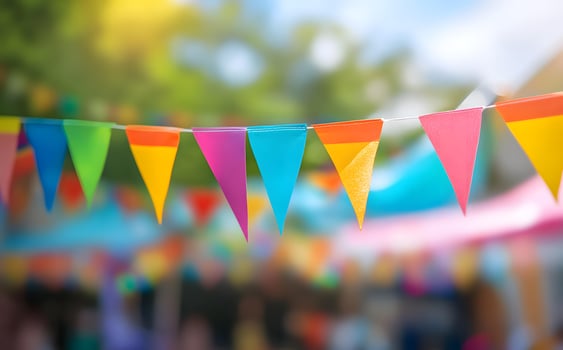 Colorful pennant banner hanging between trees creates a festive outdoor celebration atmosphere with vibrant decorations photo