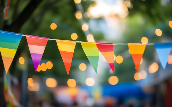 Bright rainbow triangle pennants add festive colors to an outdoor celebration against blurry lights photo