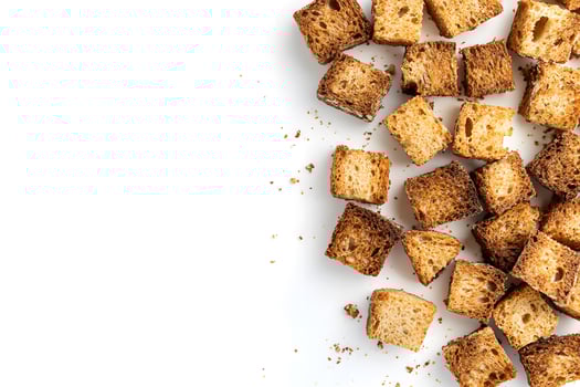 Crispy square croutons scattered artistically on clean white backdrop offer delightful textural contrast photo