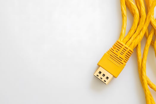 Yellow braided DisplayPort cable rests against a clean white backdrop in this detailed shot photo