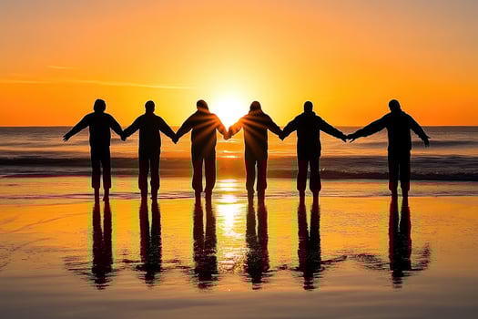 Silhouette of people holding hands at sunrise on the beach photo