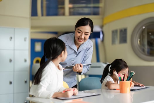Back to School Learning. Teacher assisting students in a bright classroom environment. photo