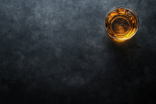 Glass of amber liquid on dark stone photo