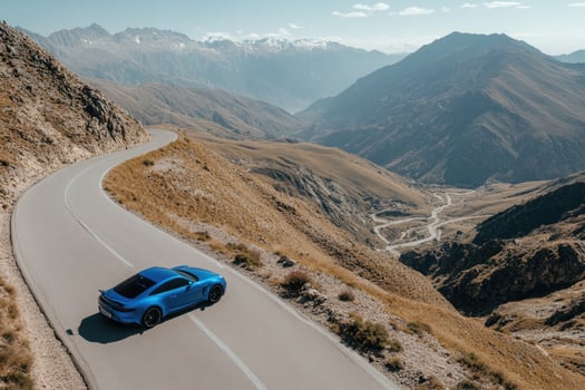 Blue sports car on winding mountain road photo