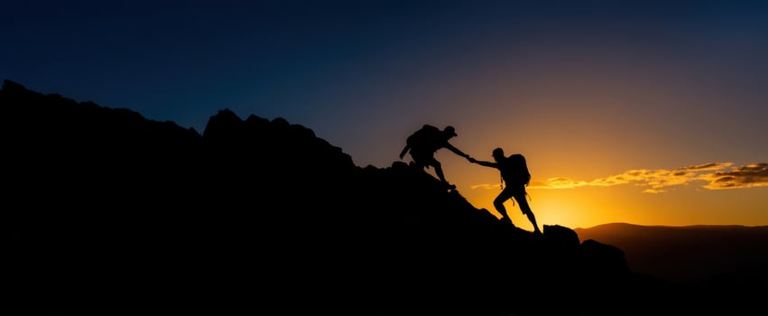 The climbers helping each other reach the summit during a breathtaking sunset. photo