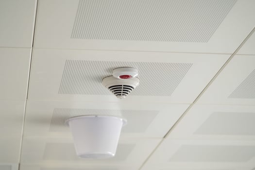 Smoke detector installed on ceiling in a modern building photo