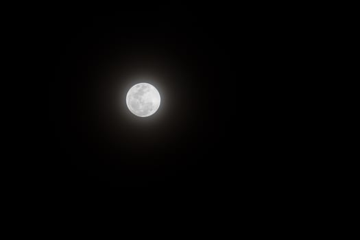 Bright full moon shines against deep night sky. photo