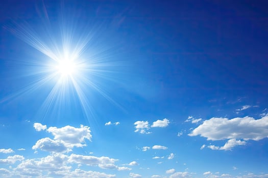 Bright sun, clear blue sky with clouds photo