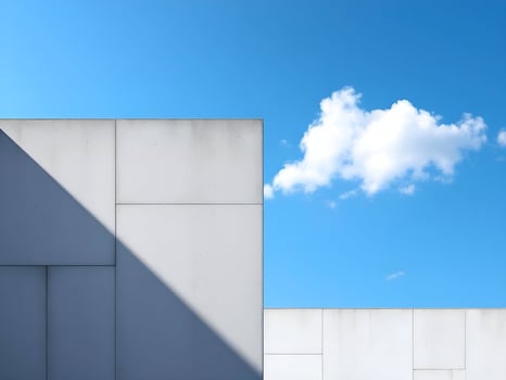 Minimalist White Building Facade Against a Clear Blue Sky with Dramatic Shadows photo