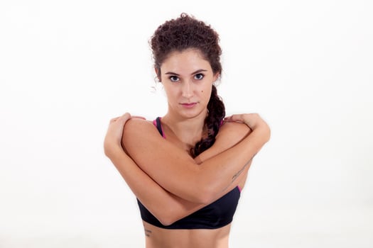 portrait of young beautiful athlete crossing arms around shoulders isolated on white background photo