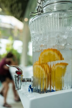 Refreshing citrus water dispenser with orange slices infused in glass jar photo