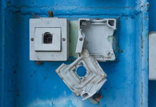 Damaged Electrical Outlet on Blue Wall photo