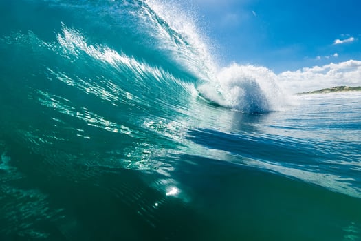 Powerful barrel wave with crystal clarity under a bright blue sky on sunny day. photo