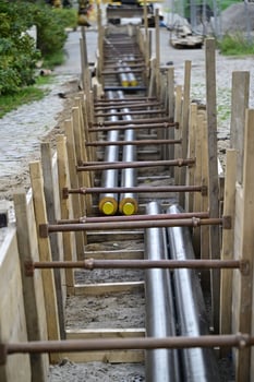 In the middle of a construction site lie the insulated metal pipes for district heating photo