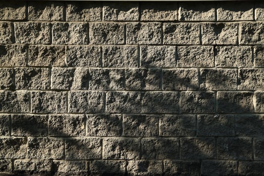 The intricate texture of a Stone Wall with Shadows conveys depth and beauty throughout the scene photo