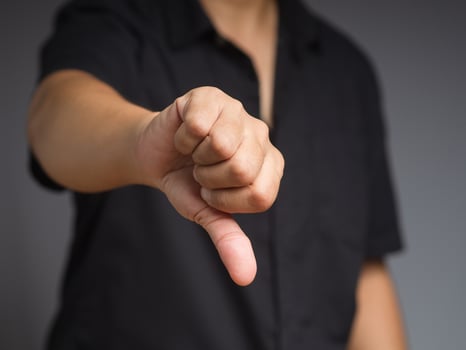Negative concept. Close-up of businessman hand showing a thumbs down for dislike service photo
