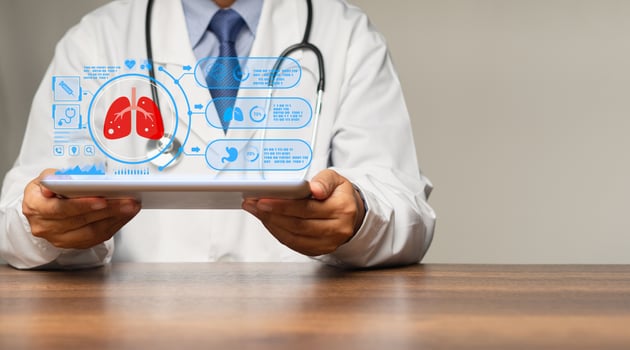 Physician reads a lung examination report on a tablet virtual display while sitting in a hospital photo