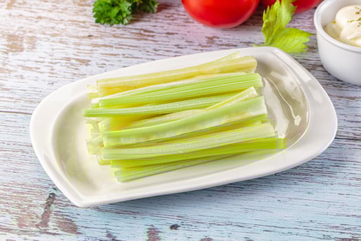 A plate of celery with a bowl of dip photo