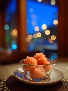Refreshing Peach Sorbet in a Glass Bowl, Nighttime Ambiance. photo