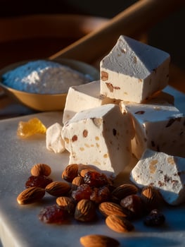 Delicious Almond and Raisin Torrone Candy Close Up. A delectable image showcasing the texture and detail of traditional Italian nougat. photo