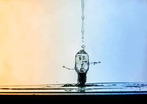 Water droplet impacting a glass bulb photo