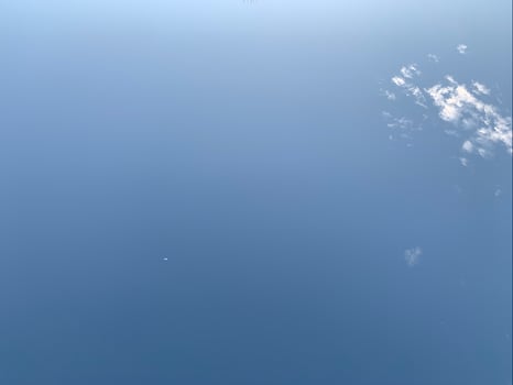 A clear blue sky with a faint crescent moon and wisps of clouds drifting gently, evoking a peaceful and serene daytime atmosphere. photo