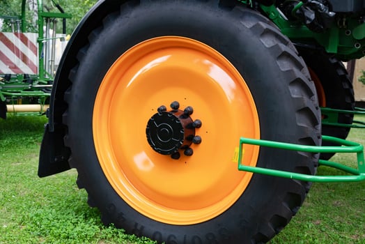 tractor wheel with orange rim on grassy ground. Farmig tire. photo
