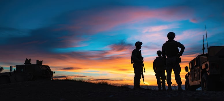 The silhouette of soldiers standing against a vibrant sunset sky. photo