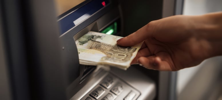 The hand withdrawing cash from an ATM in a modern banking environment. photo