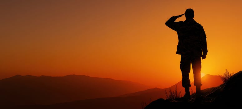 The soldier salutes against a stunning sunset backdrop, symbolizing honor and bravery. photo