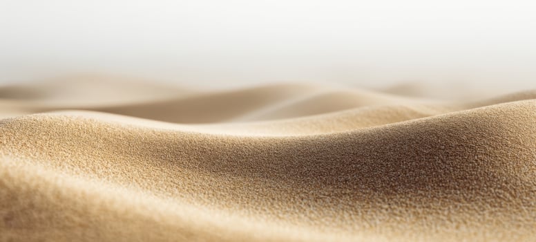 The smooth waves of golden sand creating a serene abstract landscape. photo
