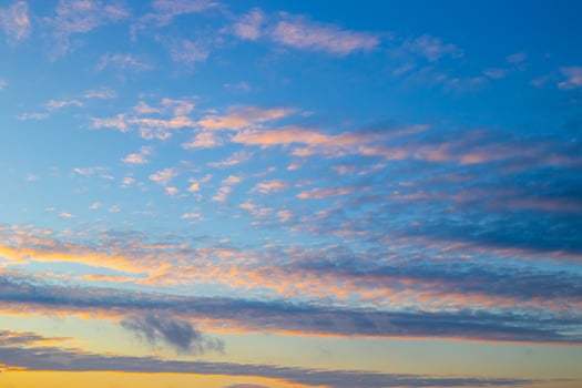 Blue evening sky with illuminated clouds at sunset. Celestial landscape photo