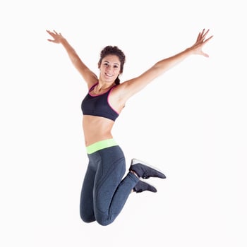 young professional athlete in sportswear having fun jumping on white background photo