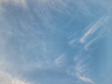 Clear blue sky with soft, wispy clouds creating a calm and peaceful atmosphere, ideal for nature, weather, or relaxation-themed visuals. photo