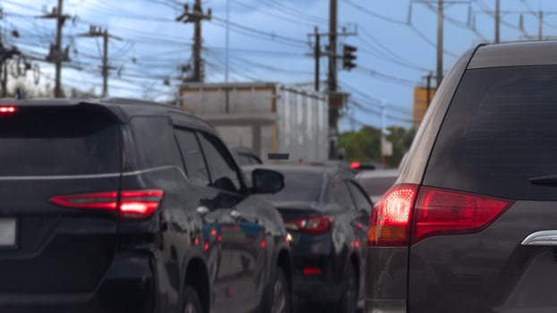 Traffic jam with several vehicles lined up on a road. Close up car with its tail lights illuminated. Traffic congestion during rush hour. photo