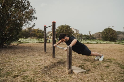 Man Does Push Ups Sport Exercise In The Park Using The Iron Bar Outside photo