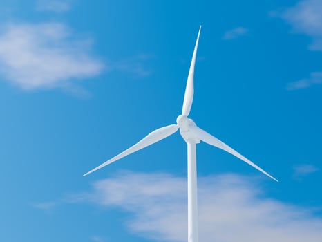 Single wind turbine with sharp blades against a bright blue sky. photo