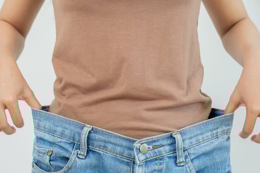 Woman show results of diet. Beautiful shape. female have a reduced waist size after under going a weight loss corse. can not wear jeans due to weight loss. balance, control, routines, exercise. photo