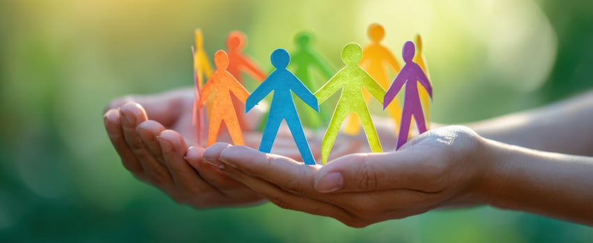 The colorful figures of unity held in caring hands in nature's light. photo
