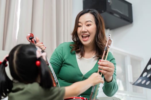 Music Education and Joyful Learning. A mother and daughter sharing a fun moment with musical instruments. photo